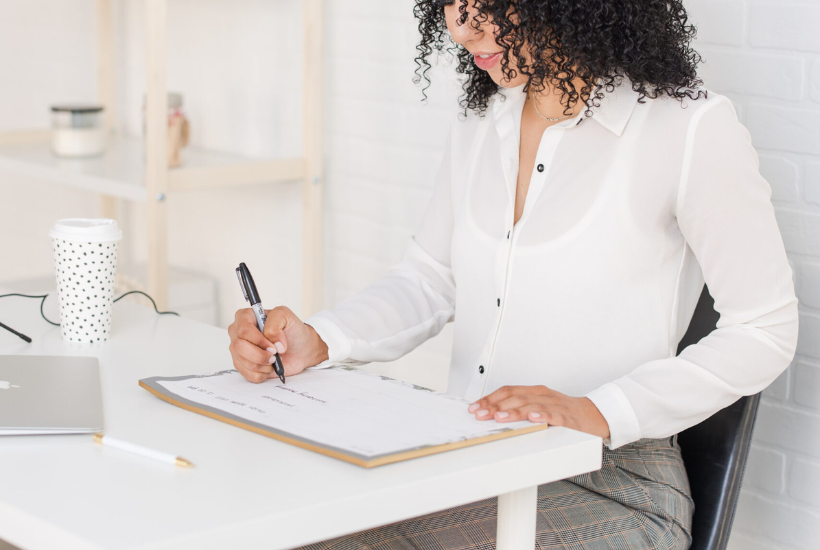 Woman writing on calendar - new year goals.